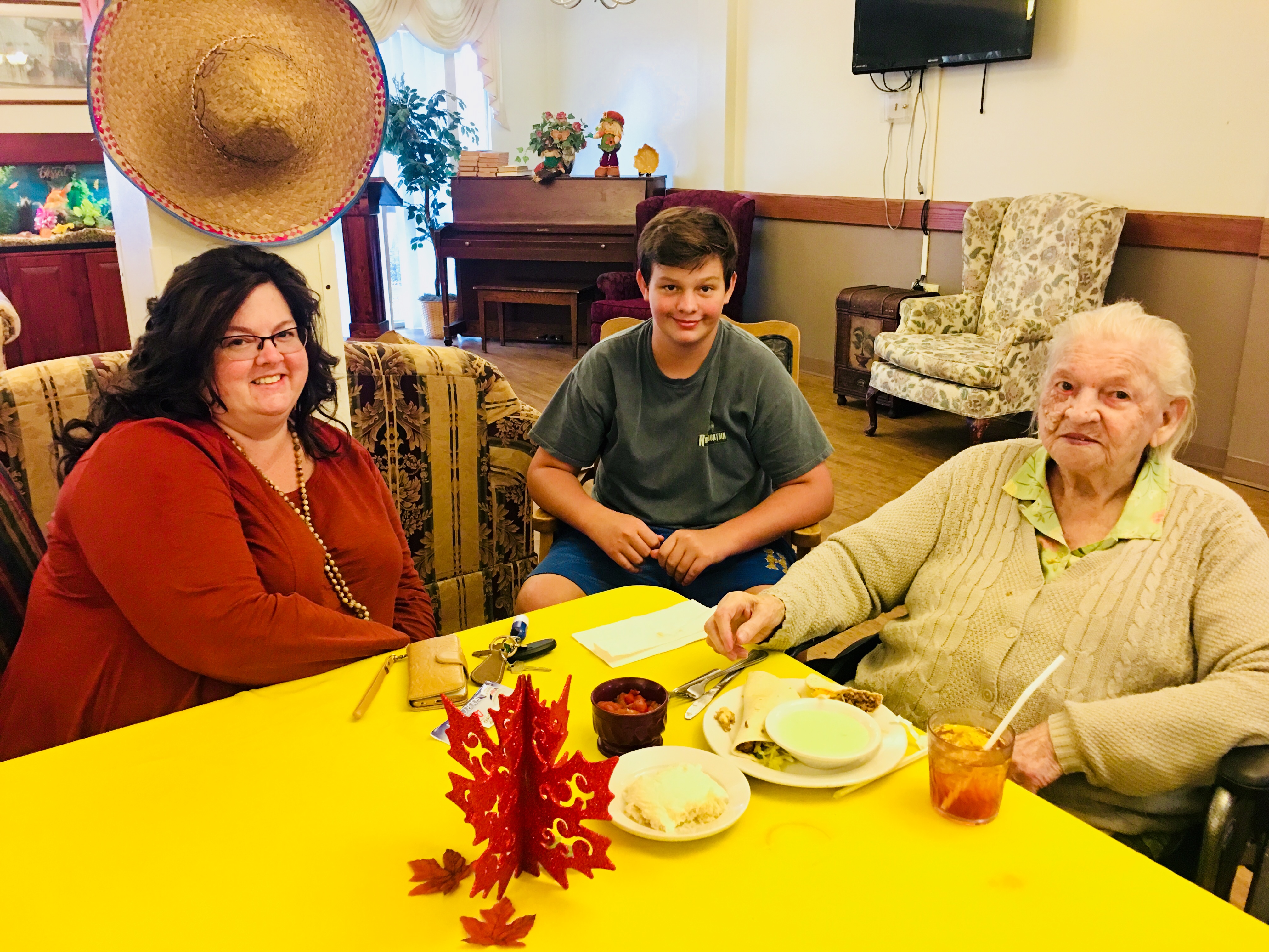 resident and family sitting at table with mexican food